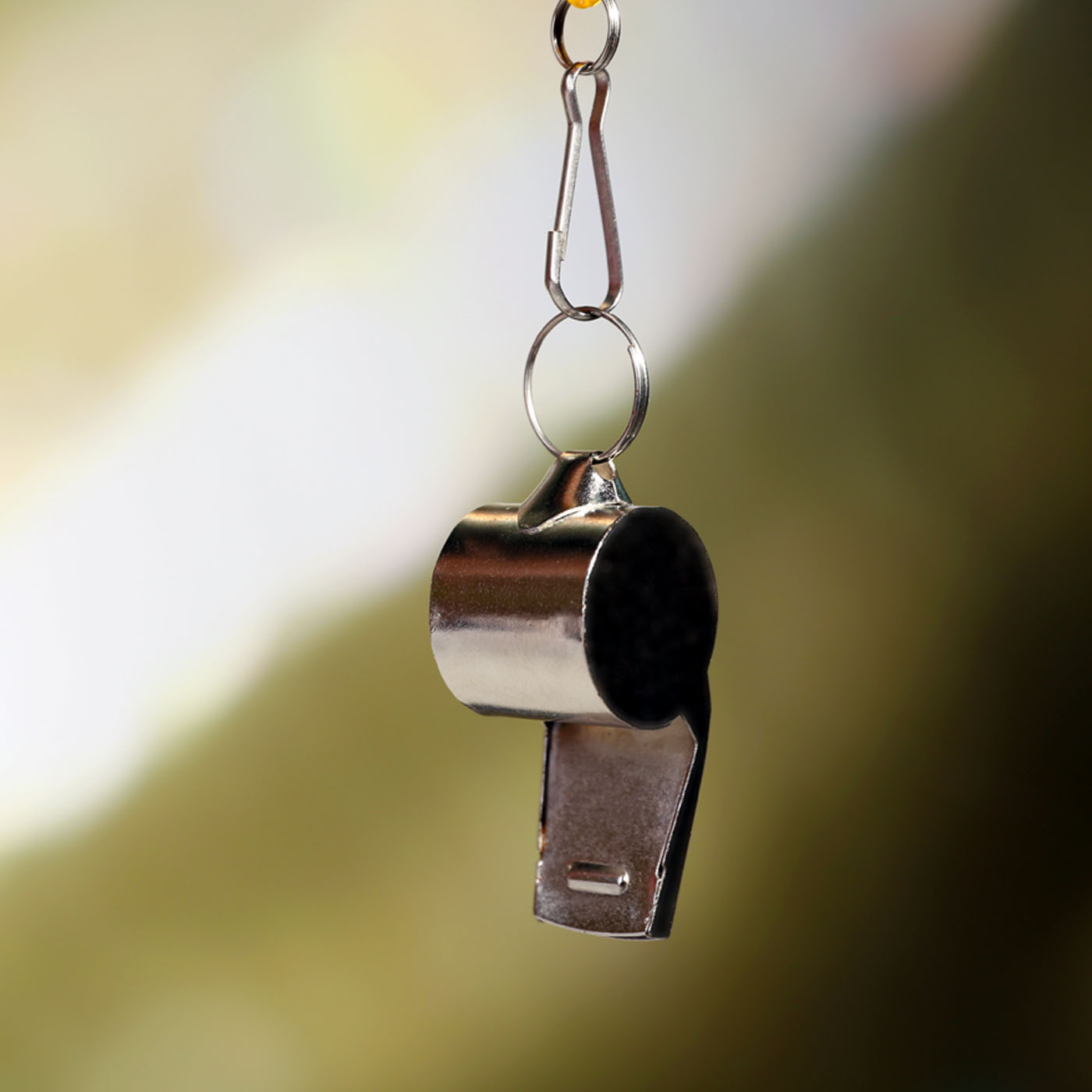 Sport metal whistle on color background