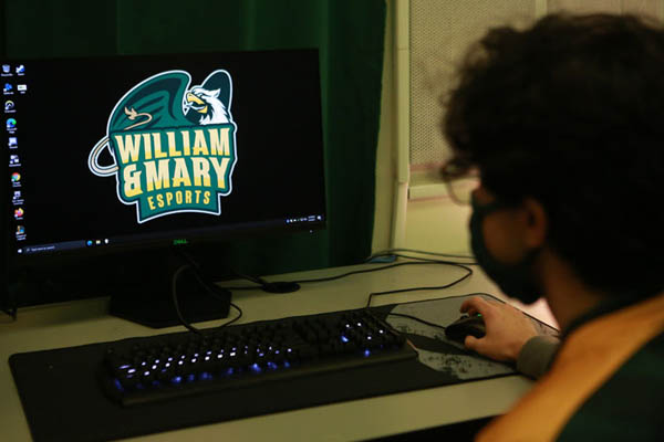 person at computer with esports logo