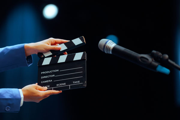 Hands holding film slate near microphone